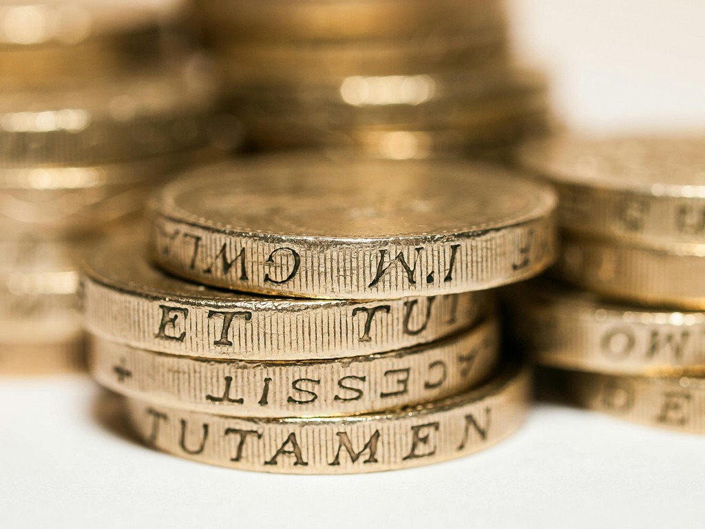 A pile of coins lies on the desk.