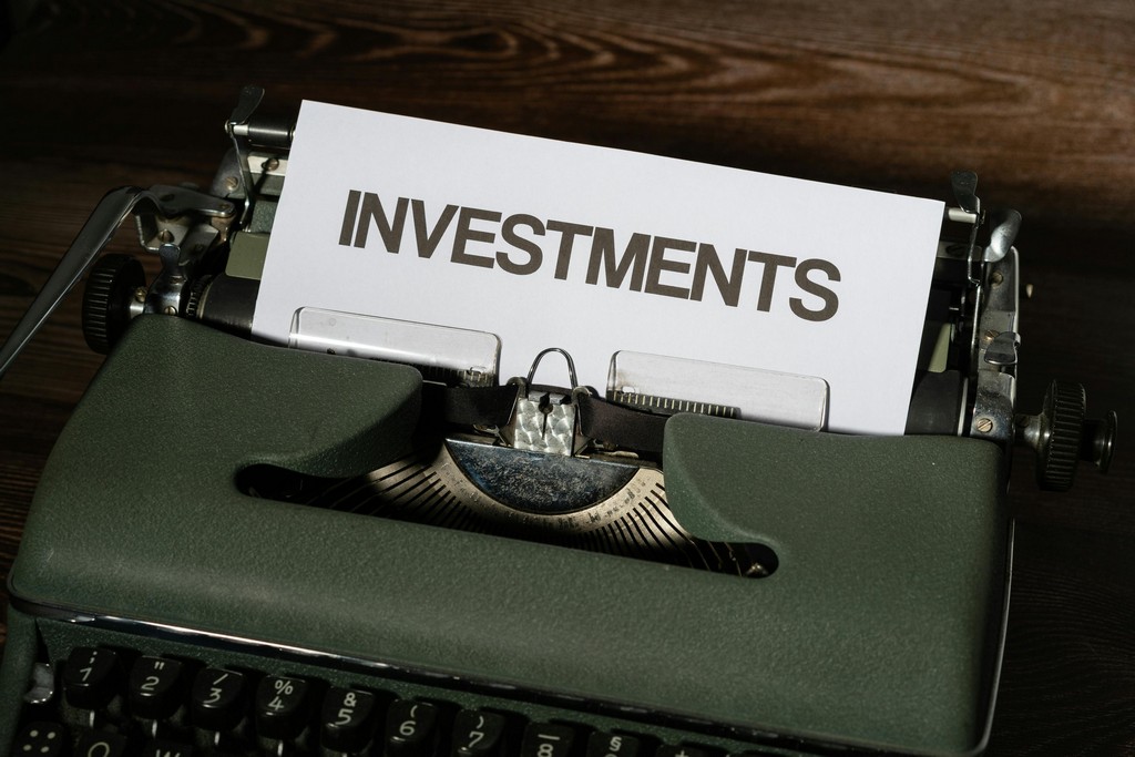 A document is coming out of a typrewriter with the word Investments across the top.