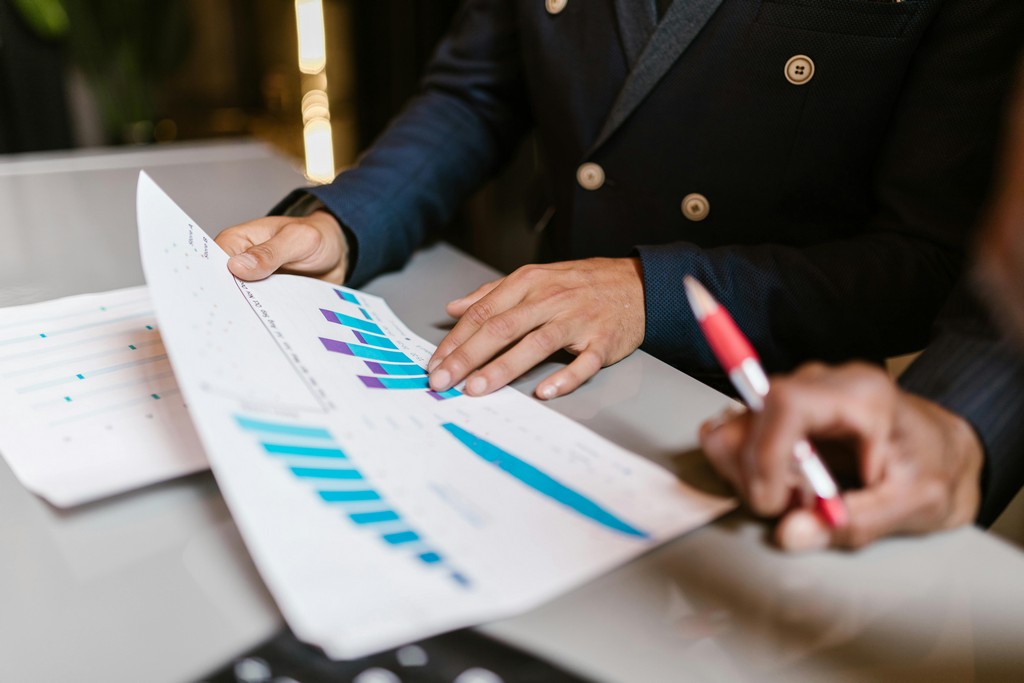 A financial professional reviewing investment charts on a computer with a client.