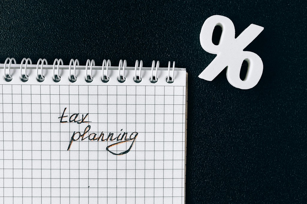 A tax planning notepad lays on the desk.