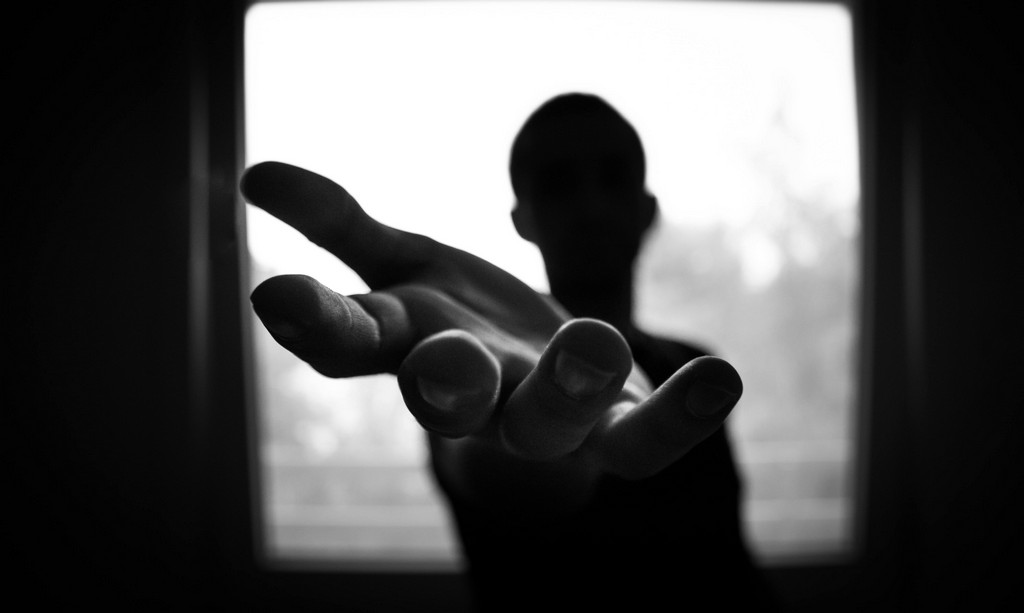 An unknown person reaches out their hand to give support.