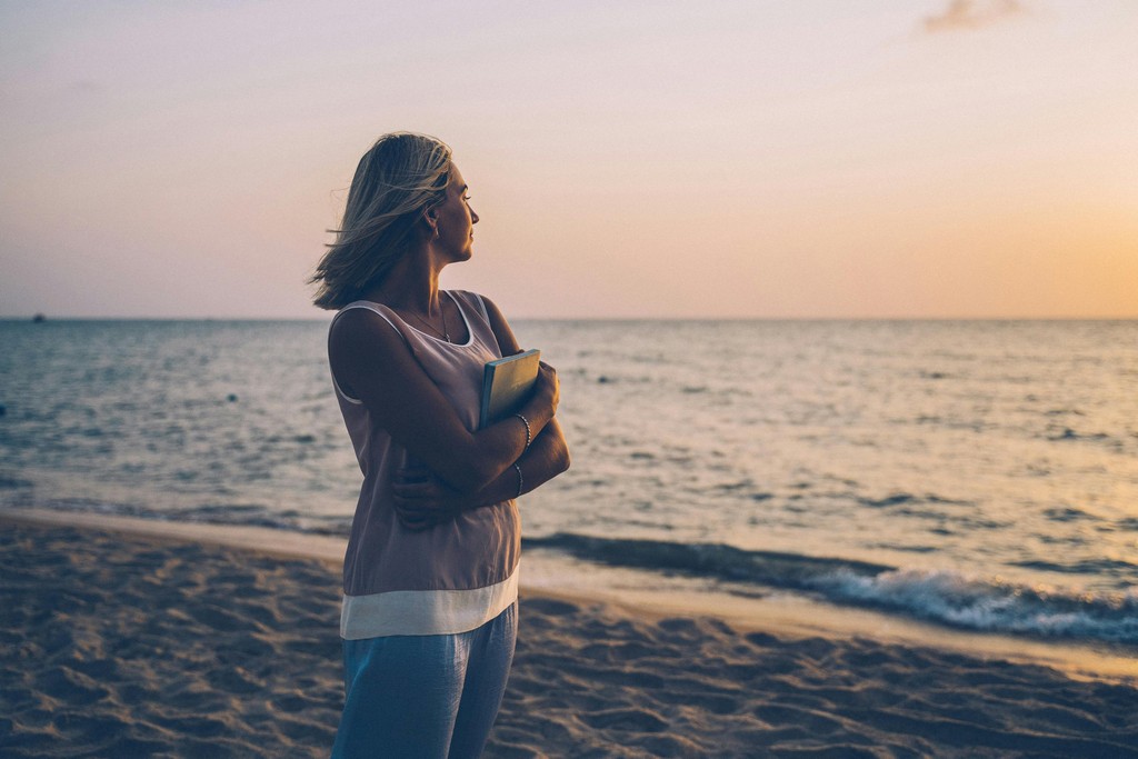 A person looking out at a calm sea, symbolising the peace of mind from comprehensive financial planning.