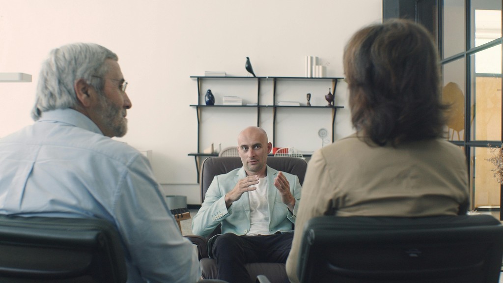 Two clients sit with a financial adviser.