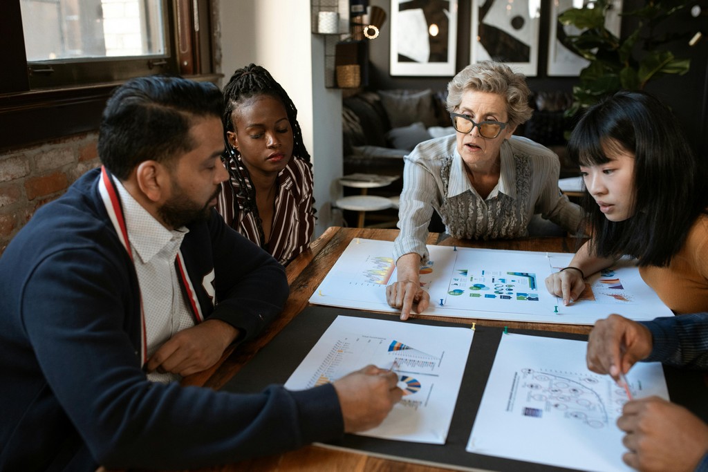 A group of people sit together and discuss a plan.
